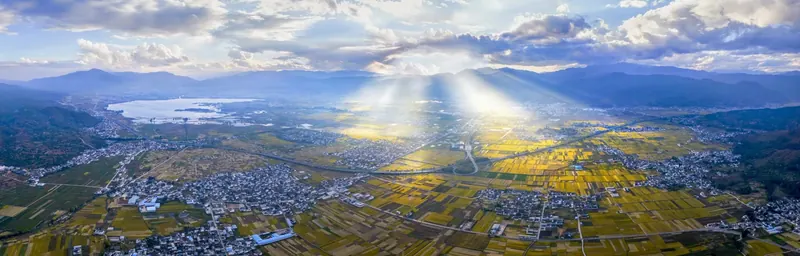 Aerial dawn view from the Cangshan Mountains over golden fields above a sea of cloud