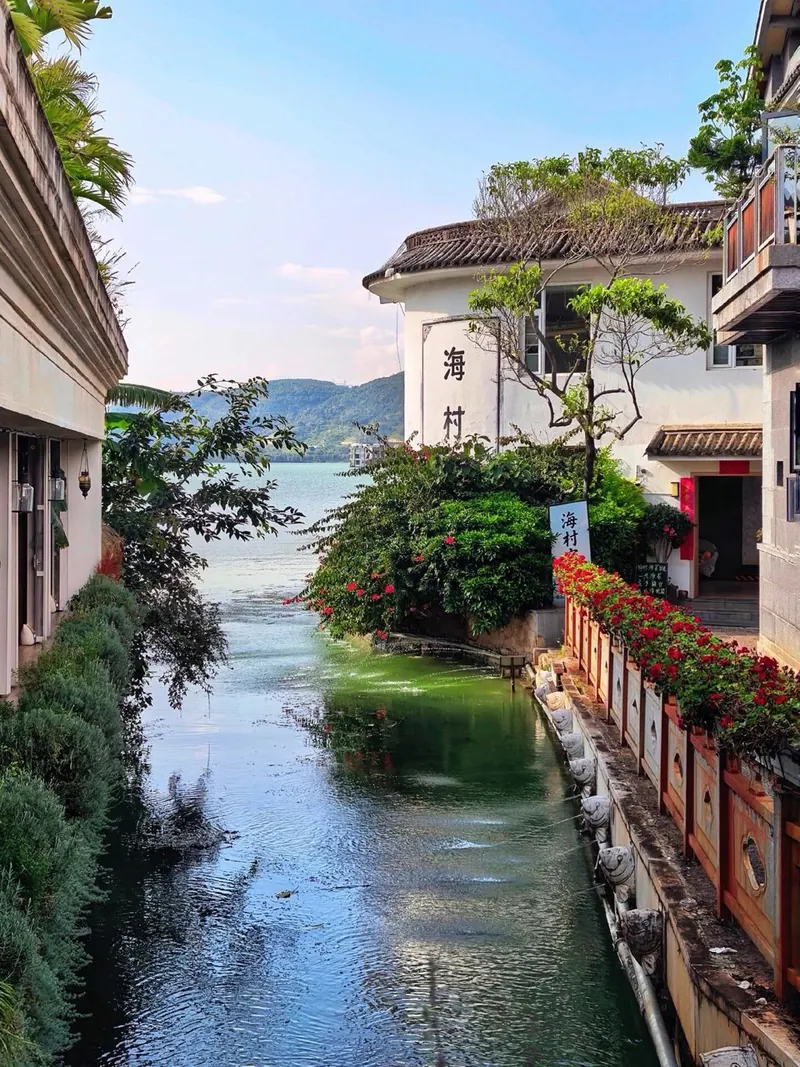 A canal lined with flowers and white houses in Shuanglang