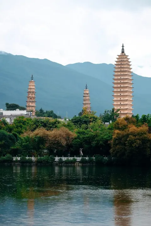 The Three Pagodas above trees and their reflection in a pool