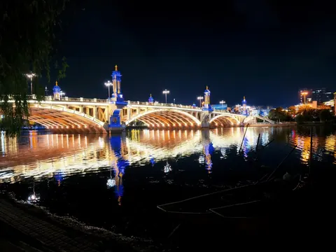 Xingsheng Bridge and its lights reflected in the Xi'er River at night